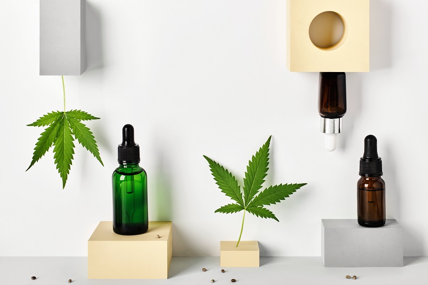 Different glass bottles with CBD oil and cannabis leaves on abstract geometric podiums. Cosmetics CBD oil concept CBD Oil and CBD Cannabis Oil products